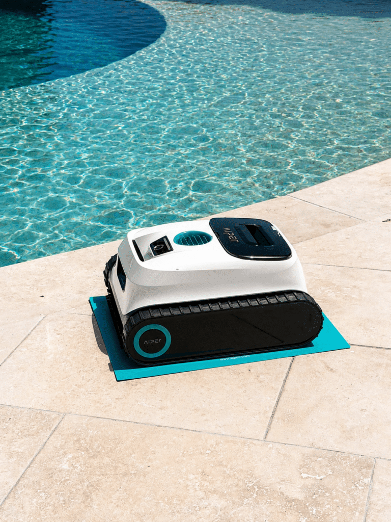 Robot de Piscine Aiper : Nettoyage Automatique Efficace Robot Aiper blanc et noir sur tapis bleu près d'une piscine.